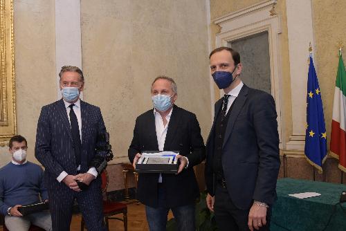 Il governatore del Friuli Venezia Giulia Massimiliano Fedriga e l'assessore regionale Fabio Scoccimarro consegnano una targa a Vasco Vascotto